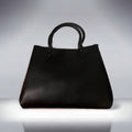 A black vegan leather mini tote bag with straps and a zipper closure.